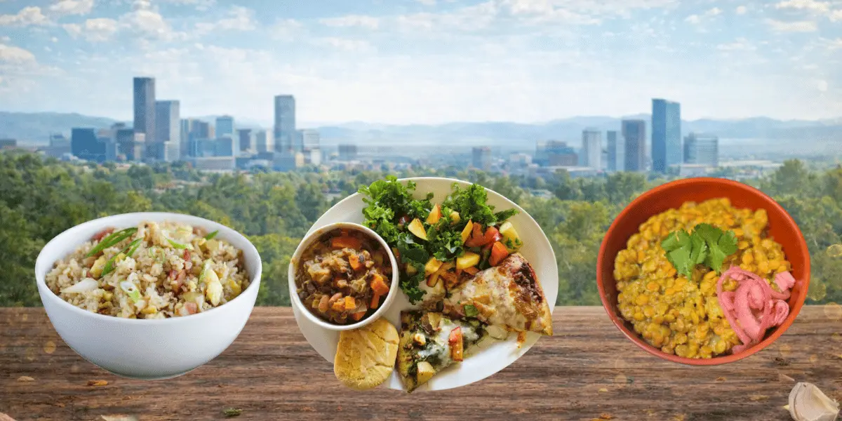 Denver skyline in the background with a wooden table in the foreground displaying three dishes made from food scraps: a vegetable soup, a mixed plate with greens and prepared items, and a lentil dish garnished with pickled onions.